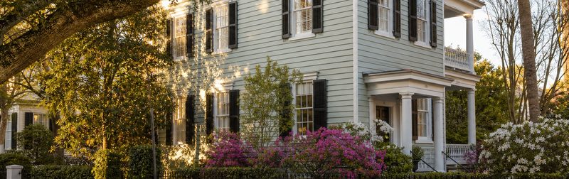 A small historic Charleston cottage with a porch