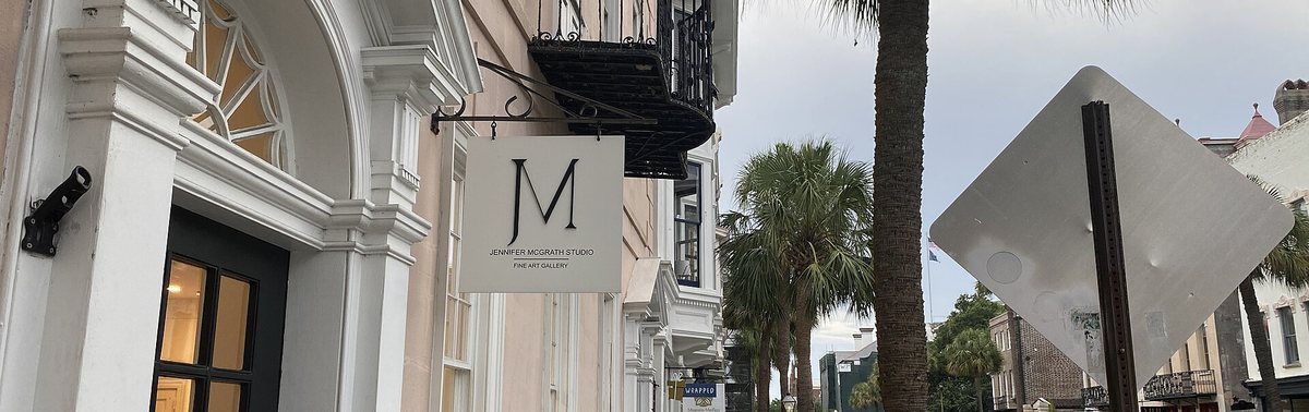 Storefront signs and palmetto trees on Broad Street in Charleston SC