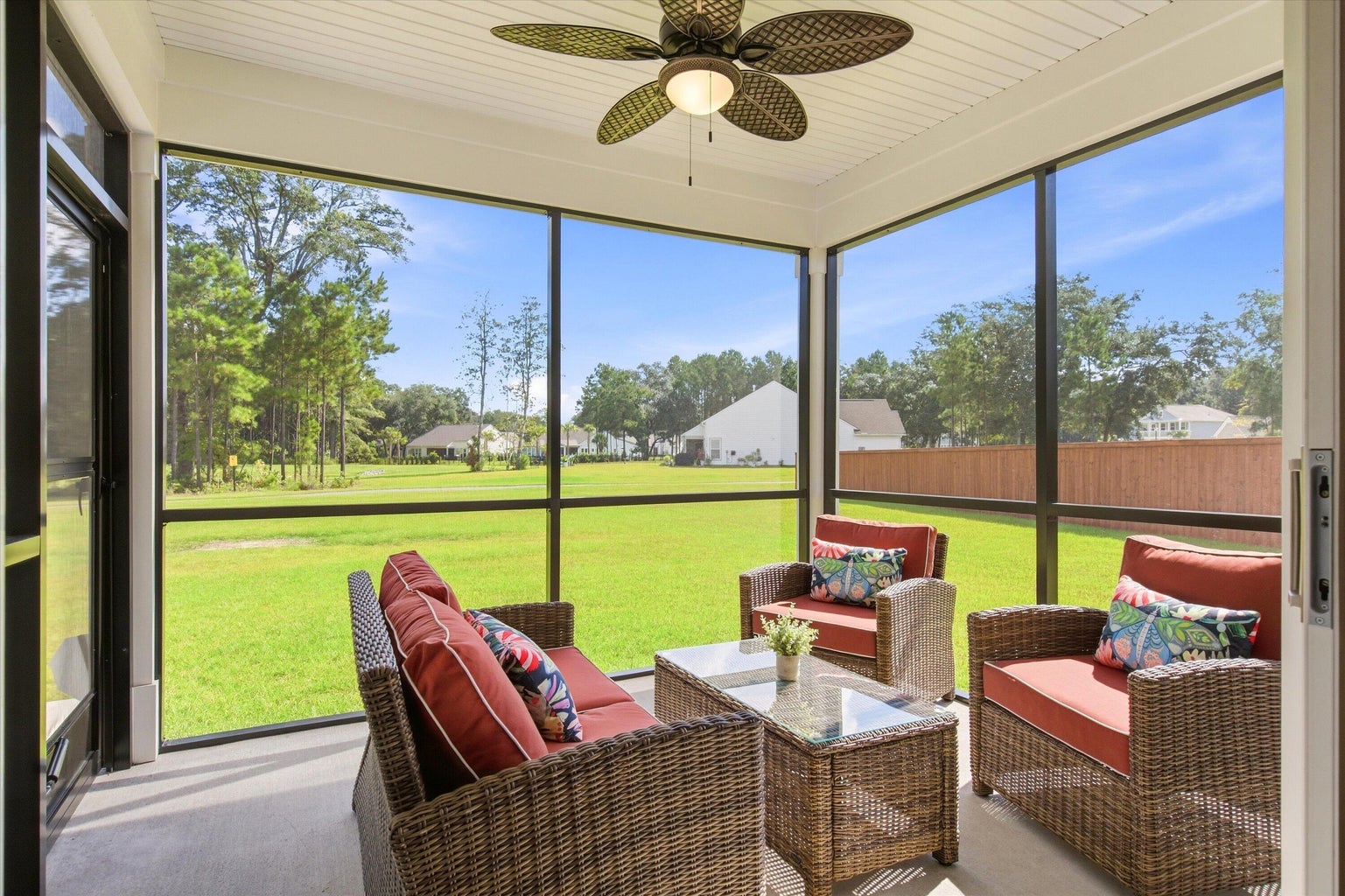 Screened porch with wicker seating looking over the lawn